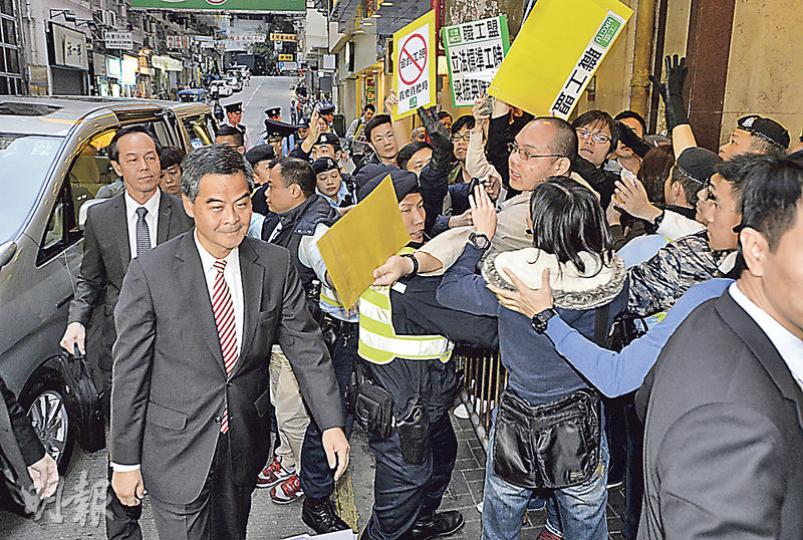 10多名職工盟成員昨日趁特首梁振英(前左)出席勞工界酒會時,在場外抗議,要求立即就標準工時立法。他們高呼口號和放紙飛機,諷刺梁振英沒有兌現立法承諾,亦向梁遞上請願信,不過梁振英未有接收。(余俊亮攝) 10多名職工盟成員昨日趁特首梁振英(前左)出席勞工界酒會時,在場外抗議,要求立即就標準工時立法。他們高呼口號和放紙飛機,諷刺梁振英沒有兌現立法承諾,亦向梁遞上請願信,不過梁振英未有接收。(余俊亮攝)