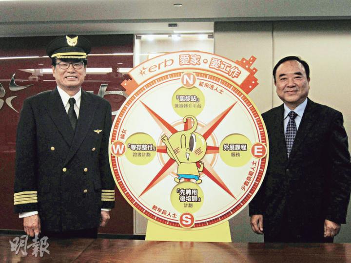 僱員再培訓局主席梁永祥(左)昨日以一身飛機師打扮出席傳媒茶敘,圖中「羅盤」寓意新的培訓課程有四大方向,照顧少數族裔、年長人士、婦女及新來港人士的需要,冀學員畢業後可一飛冲天。圖右為僱員再培訓局行政總監吳家光。(錢瑋琪攝) 僱員再培訓局主席梁永祥(左)昨日以一身飛機師打扮出席傳媒茶敘,圖中「羅盤」寓意新的培訓課程有四大方向,照顧少數族裔、年長人士、婦女及新來港人士的需要,冀學員畢業後可一飛冲天。圖右為僱員再培訓局行政總監吳家光。(錢瑋琪攝)