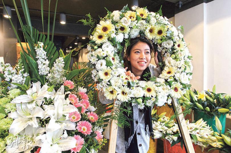 近年不少大型殯儀花店都改製西式花籃及花圈,工序較中式花牌省時之餘,保鮮度亦更長,年輕殯儀花店老闆娘陳惠雅喜愛創新,把花店當成實驗室,自行染花製作特別花牌。(林俊源攝)製作中式花牌要先用手扳開竹篾,將其一開三,再把花朵插在竹篾上,然後逐一插在乾草球上,工序繁複。(陳顥之攝) 近年不少大型殯儀花店都改製西式花籃及花圈,工序較中式花牌省時之餘,保鮮度亦更長,年輕殯儀花店老闆娘陳惠雅喜愛創新,把花店當成實驗室,自行染花製作特別花牌。(林俊源攝)製作中式花牌要先用手扳開竹篾,將其一開三,再把花朵插在竹篾上,然後逐一插在乾草球上,工序繁複。(陳顥之攝)