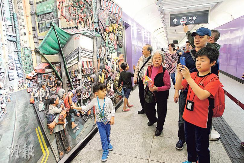 西營盤站以紫色為主調,位於B出口的彩色市集浮雕最受市民歡迎。由藝術家Louise Soloway Chan創作的6幅浮雕畫,描繪西營盤海味店及街市等舊式店舖。啟用第一天已吸引不少市民爭相拍攝。(林俊源攝) 西營盤站以紫色為主調,位於B出口的彩色市集浮雕最受市民歡迎。由藝術家Louise Soloway Chan創作的6幅浮雕畫,描繪西營盤海味店及街市等舊式店舖。啟用第一天已吸引不少市民爭相拍攝。(林俊源攝)