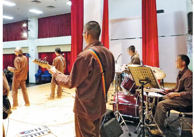 赤柱監獄的Time樂隊現時有7名成員,擅長曲目除陳百強的《喝采》、《摘星》等勵志歌曲,亦包括較新歌曲如陳奕迅的《單車》。牧師黃子坤說,有時會將內地熱播節目《中國好聲音》的影碟帶進獄中,供樂隊成員參考。訪問當天,樂隊其餘成員在監獄禮堂一起演奏後,知道台前兩人阿全(圖中左一)及Armani(圖中左二)因即將受訪感到緊張,離開前特地回頭大喊「加油!支持你們!」(陳倢朗攝) 赤柱監獄的Time樂隊現時有7名成員,擅長曲目除陳百強的《喝采》、《摘星》等勵志歌曲,亦包括較新歌曲如陳奕迅的《單車》。牧師黃子坤說,有時會將內地熱播節目《中國好聲音》的影碟帶進獄中,供樂隊成員參考。訪問當天,樂隊其餘成員在監獄禮堂一起演奏後,知道台前兩人阿全(圖中左一)及Armani(圖中左二)因即將受訪感到緊張,離開前特地回頭大喊「加油!支持你們!」(陳倢朗攝)