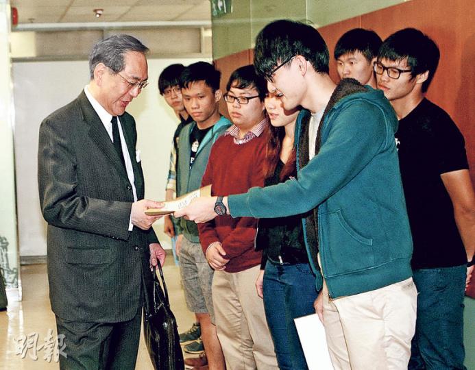港大學生會10多名成員昨在校委會會議室外向新任校務委員李國章（左）請願，由會長馮敬恩（藍色外套者）遞公開信，要求李辭職及就他指港大教師「不務正業」的言論道歉，李收信後說「多謝你哋」便進入會議室。（郭慶輝攝）