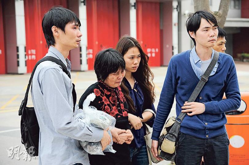 死者譚振平的家人包括長子（左一）、妻子（左二）、次子（右一）等，昨到場現場了解情况，拾回死者物品，當中譚妻不注哭泣。（賴俊傑攝）