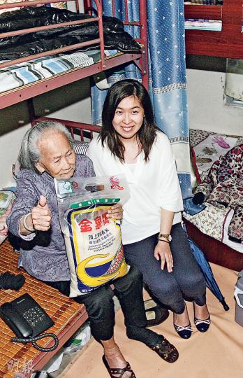 屈婆婆（左）被無良賊搶去綜援金，街坊紛紛送暖，其中筲箕灣民生關注組成員（右）昨日帶同食米等物資登門探訪，屈婆婆開心得豎拇指答謝。（伍浦鋒攝）