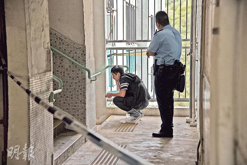 頭有刀傷的八旬老婦在大廈走廊欄杆上吊，送院後不治，警方一度認為案件有可疑，封鎖案發現場調查。（林智傑攝）