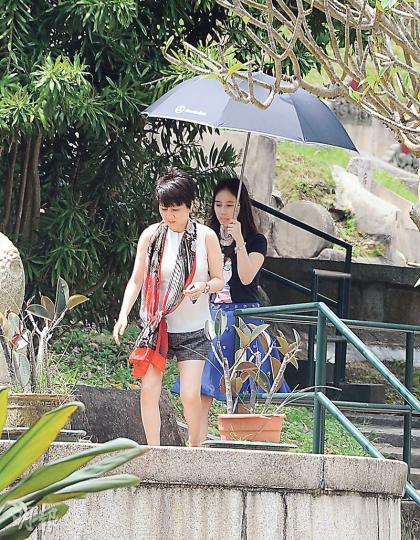 四太梁安琪與女兒何超欣到家族墓園向先人致祭，盡孝子賢孫之道。超欣更乖巧地為母親舉傘擋太陽。（攝影：鍾偉茵）