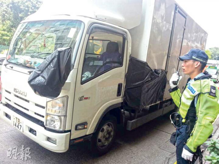 尖沙嘴致命車禍中，警方用黑色膠袋將懷疑撞及死者的部分包裹，並將車拖走檢驗。（衛永康攝）