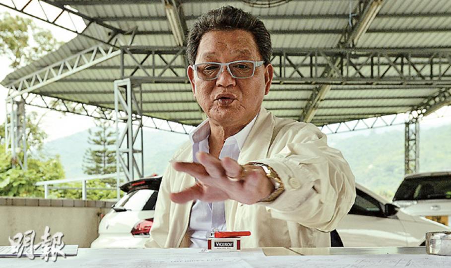 協助地主在南生圍壆圍村漁塘收地的簡彩明，在本報記者留下卡片後第二天便答應接受訪問，當日他拿來地圖（圖前）、租約和法律文件解說。他說﹕「其實我只是吊兩舊石，諗住塞住路口，咁樣啫。」他強調自己沒有犯法，沒破壞對方的財產。但他說，當初若由執達吏收地，便不用搞出現時「大頭佛」。他又表示自己曾手持逾百個丁權，以及協助發展商搞丁屋，惟近年已轉低調，主要在內地居住。（余俊亮攝）去年9月，簡彩明派人放置巨石於蘇家魚塘其中一個出口前方，至今逾半年，巨石仍在。蘇家稱放石的大漢當中，有人自稱黑社會，故掛了寫有「黑社會