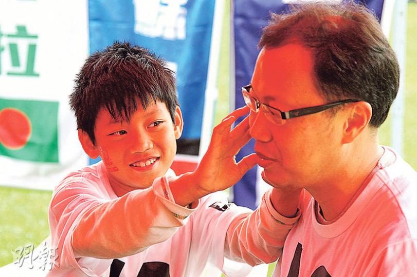 11歲的馮念照（左）與爸爸（右）相隔兩年再參加「饑饉三十」，念照表示，初次捱餓經驗令他感受到貧困孩子的生活，他們一家去年更助養一名12歲北非女孩，馮爸爸希望可以用行動影響下一代，把行善變成一種習慣。（林俊源攝）
