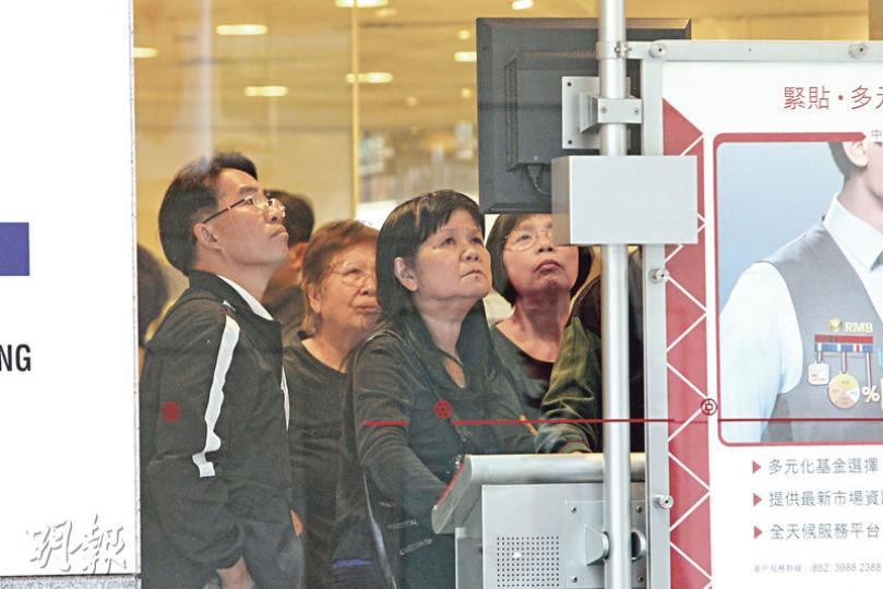 全城狂炒股，在證券行及銀行內，多名股民聚精會神留意市况變化，惟昨日恒指結束8連升，回調逾450點，但基金經理仍看好後市。（林俊源攝）