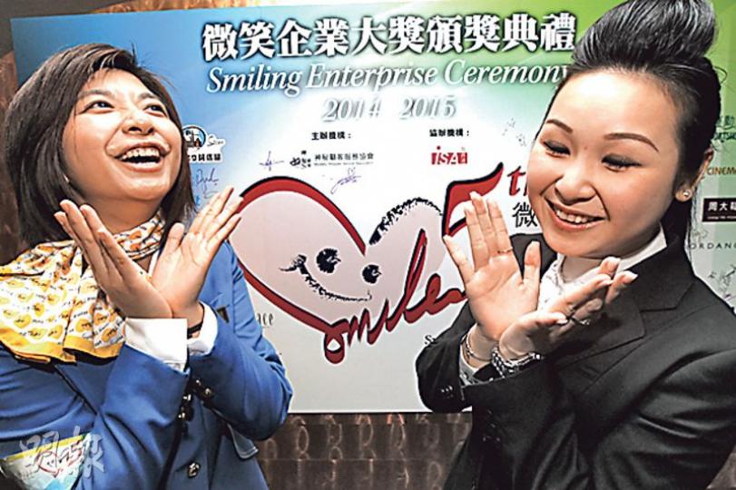 神秘顧客服務協會發布「全球微笑報告」，香港評分大跌，所以呼籲大家笑多啲。協會仲舉辦頒獎禮，搵咗獲微笑獎嘅康泰旅行社旅遊顧問黃美玲（左）及周大福珠寶金行營業員許曉恩示範笑容。（李紹昌攝）