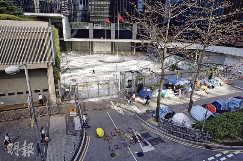 現時政府總部外仍有多個帳幕駐紮，「公民廣場」則維持封鎖，政總東翼地下則長期落閘，以防有人衝擊，訪客需要經天橋到上層入口登記才能進入。（李紹昌攝）立法會外的「公民廣場」去年起加強保安，加設圍欄及鐵馬，據了解，行管會最快下周二討論進一步收緊大樓保安。（李紹昌攝）去年持續79日的佔領行動已完結，但至今仍有不少人在立法會外紮營爭取真普選。（李紹昌攝）
