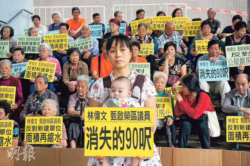 約100名石硤尾及白田邨居民到何文田房屋總署請願，劉女士（圖中）帶同兒子抗議。劉女士一家現居於白田邨一個290呎單位，擔心搬至「縮水」新公屋時，小朋友會缺少空間走動。（黎明芝攝）
