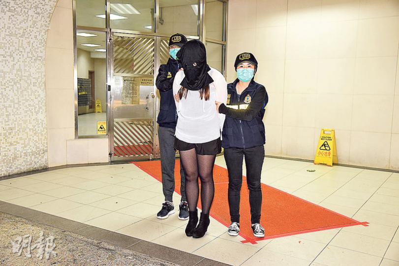 一名女文員涉嫌運毒被捕,被蒙頭帶回家調查。(蔡方山攝) 一名女文員涉嫌運毒被捕,被蒙頭帶回家調查。(蔡方山攝)