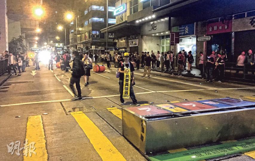 大批市民昨日凌晨在旺角警署外聚集,要求警方釋放被捕的「鳩嗚」示威者,有人更一度拉出大型回收箱堵塞一段太子道西,但警方迅速掩至將障礙物移離。(明報記者攝) 大批市民昨日凌晨在旺角警署外聚集,要求警方釋放被捕的「鳩嗚」示威者,有人更一度拉出大型回收箱堵塞一段太子道西,但警方迅速掩至將障礙物移離。(明報記者攝)