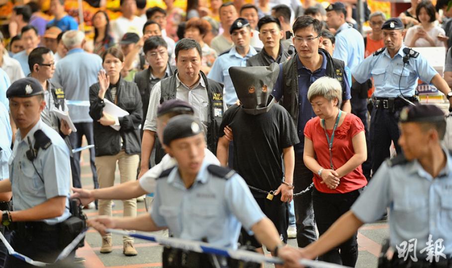 被捕的29歲鄭姓疑犯,昨日黑布蒙頭,腰間及雙手鎖上鐵鏈,由探員押解至牛池灣一帶重組案情,身旁一名女子負責翻譯,大批機動部隊警員拉起封鎖線開路。(葉家豪攝) 被捕的29歲鄭姓疑犯,昨日黑布蒙頭,腰間及雙手鎖上鐵鏈,由探員押解至牛池灣一帶重組案情,身旁一名女子負責翻譯,大批機動部隊警員拉起封鎖線開路。(葉家豪攝)