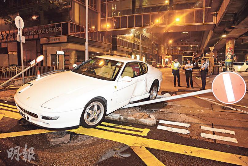 車價達220萬元白色法拉利跑車，昨凌晨在金鐘剷上安全島撞毁路牌及燈箱，司機不知所終。（蔡方山攝）