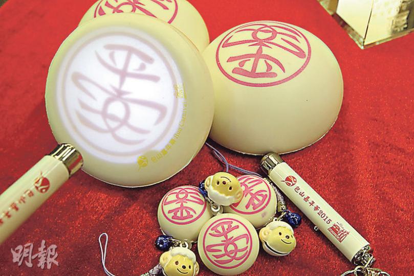 今年參加包山嘉年華的市民可獲贈免費禮品,包括一個掛有羊生肖裝飾的小平安包(圖下方),及一支可投射出「平安」字樣的小電筒。另外市民亦可在搶包山比賽完結後,憑票換領一個包山上的平安包。(郭慶輝攝) 今年參加包山嘉年華的市民可獲贈免費禮品,包括一個掛有羊生肖裝飾的小平安包(圖下方),及一支可投射出「平安」字樣的小電筒。另外市民亦可在搶包山比賽完結後,憑票換領一個包山上的平安包。(郭慶輝攝)