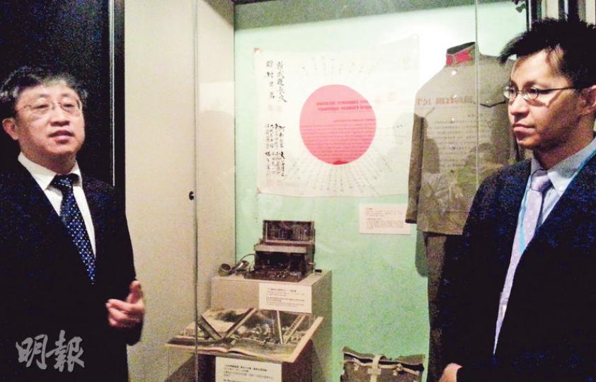 海防博物館一級助理館長李家樂(右)透露,其背後的日軍軍旗由本港一市民借出,旗上記錄日軍在1936至1938年曾到上海、東北及廣州等地。旁為合辦展覽的廣東革命歷史博物館館長楊琪。(岑詠欣攝) 海防博物館一級助理館長李家樂(右)透露,其背後的日軍軍旗由本港一市民借出,旗上記錄日軍在1936至1938年曾到上海、東北及廣州等地。旁為合辦展覽的廣東革命歷史博物館館長楊琪。(岑詠欣攝)
