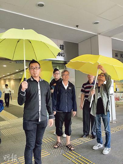 被控「導致公眾地方遭受阻礙」的被告歐陽東(左一),昨於庭外與支持者一起撐起黃傘。(黃建邦攝) 被控「導致公眾地方遭受阻礙」的被告歐陽東(左一),昨於庭外與支持者一起撐起黃傘。(黃建邦攝)