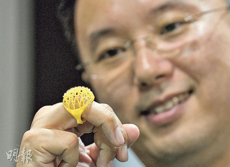 生產力促進局自動化科技部首席顧問蘇文傑(圖)手上戴着的塑膠戒指模具,以數碼影像投射成形首辦機,用了約3小時打印,較人手雕刻快數倍。(余俊亮攝)早期的3D打印技術只可打印較簡單的形狀,生產力區引入的先進數碼影像投射成形首辦機(圖)則能打印十分精細的物件。該打印機價值數十萬元,以立體軟件設計好的物件,可在兩三小時內完成打印,若以人手雕刻至少需時一日。(余俊亮攝) 生產力促進局自動化科技部首席顧問蘇文傑(圖)手上戴着的塑膠戒指模具,以數碼影像投射成形首辦機,用了約3小時打印,較人手雕刻快數倍。(余俊亮攝)早期的3D打印技術只可打印較簡單的形狀,生產力區引入的先進數碼影像投射成形首辦機(圖)則能打印十分精細的物件。該打印機價值數十萬元,以立體軟件設計好的物件,可在兩三小時內完成打印,若以人手雕刻至少需時一日。(余俊亮攝)