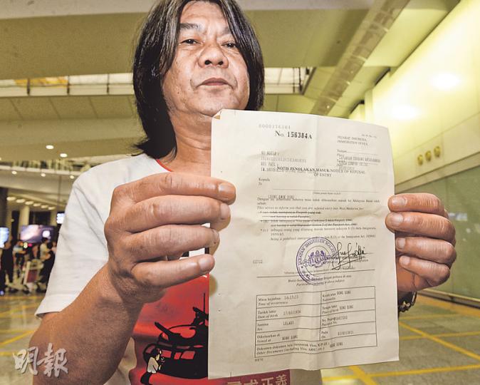 立法會議員梁國雄回港後向記者展示被拒入境通知書,文件指他違反馬來西亞入境條例,但無解釋原因。梁說當地人員一度取去他的護照,但回港前歸還。(劉焌陶攝) 立法會議員梁國雄回港後向記者展示被拒入境通知書,文件指他違反馬來西亞入境條例,但無解釋原因。梁說當地人員一度取去他的護照,但回港前歸還。(劉焌陶攝)