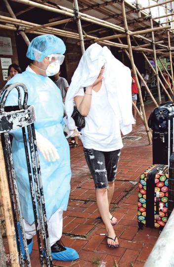 其中一名拒絕隔離的韓國籍女子昨午在伊利莎伯大廈A座被衛生防護中心人員帶走，連同行李（圖右下）一併送入隔離營，但她見記者拍攝即以衣物遮頭。（李紹昌攝）經港赴惠州的韓男確診中東呼吸綜合症後，西貢麥理浩夫人度假村再成為隔離營，曾與他同機有密切接觸的18人昨全部入營隔離檢疫。（余俊亮攝）