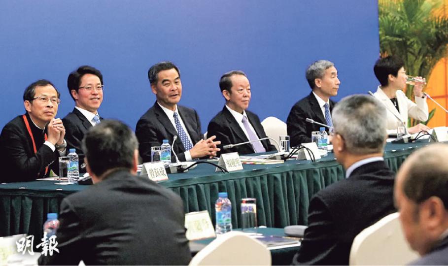 立會議員昨晨到深圳與3名京官交流，京官獲安排坐在會議廳前排的主席枱位置，面對一眾議員。在座位安排上，左起是立法會主席曾鈺成、中聯辦主任張曉明、特首梁振英、港澳辦主任王光亞、基本法委員會主任李飛及任交流會主持的政務司長林鄭月娥。有泛民議員指出，在交流會中未發一言的梁振英，與王光亞一起坐在中間位置，分隔了張曉明，安排上有別於去年上海交流會，估計中央是想傳遞在政改問題上撐梁振英的意思。（林俊源攝）3名京官昨日與立法會議員交流後會見記者，會場以一條紅色布欄分隔京官與記者位置。京官在記者會上講明中央底線，