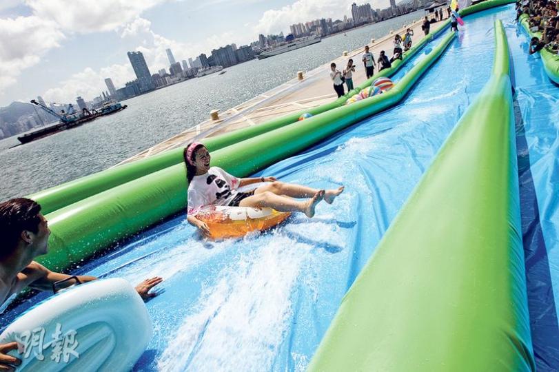 8月底在啟德舉行的「Slide the City」,可讓入場者在千呎長水道上滑行。圖中的滑水道只有50呎長,是主辦機構專為昨天的啟動禮而設置。(李紹昌攝) 8月底在啟德舉行的「Slide the City」,可讓入場者在千呎長水道上滑行。圖中的滑水道只有50呎長,是主辦機構專為昨天的啟動禮而設置。(李紹昌攝)
