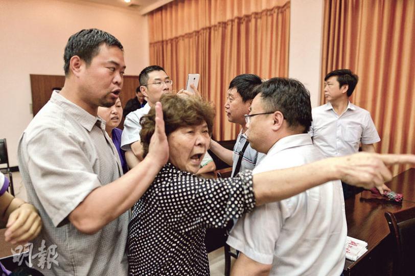 一名信訪辦官員稱要先核實家屬身分,引起家屬(前中)情緒激動。(鄧宗弘攝) 一名信訪辦官員稱要先核實家屬身分,引起家屬(前中)情緒激動。(鄧宗弘攝)