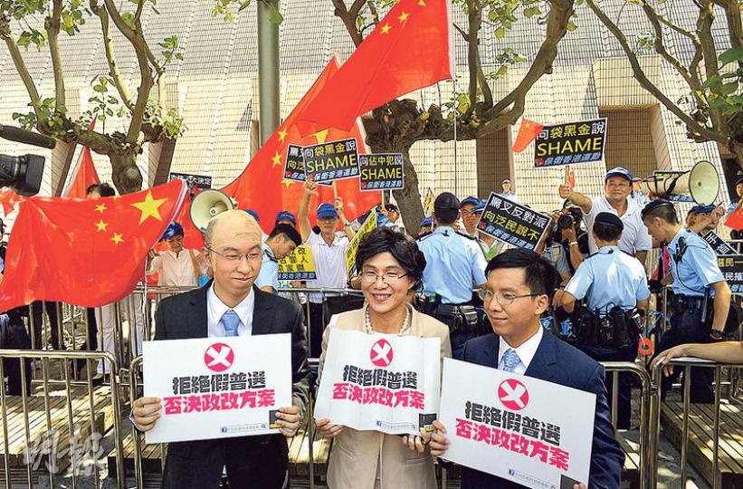 「保衛香港運動」及泛民等團體昨日同在尖沙嘴文化中心對出位置舉行集會。模仿政改三人組的自發團體「政改奸人組」一度站在保衛香港運動前拍照,反對政改袋住先。支持政改的參與者則在後方大叫「洋奴」等口號反擊。(余俊亮攝) 「保衛香港運動」及泛民等團體昨日同在尖沙嘴文化中心對出位置舉行集會。模仿政改三人組的自發團體「政改奸人組」一度站在保衛香港運動前拍照,反對政改袋住先。支持政改的參與者則在後方大叫「洋奴」等口號反擊。(余俊亮攝)