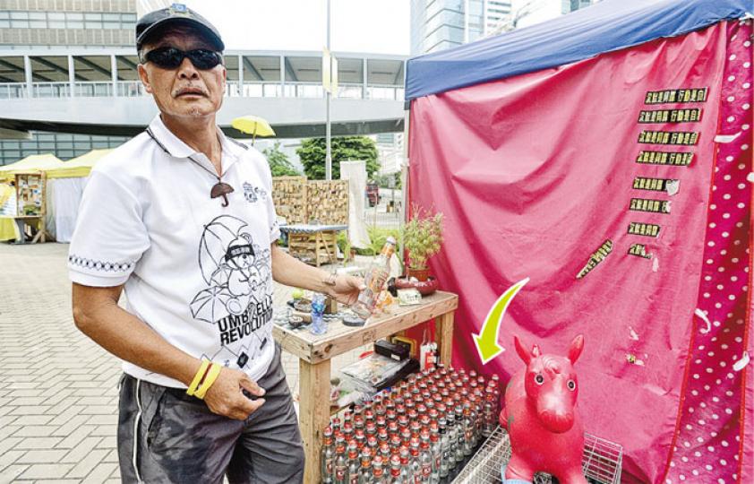 有傳媒發現,在立法會及政總門外一帶的「帳篷陣」內,有露宿者儲起大批玻璃樽(箭嘴示),質疑是用來盛載辣椒油,作為與警員對峙時投擲之用。物主劉先生解釋,酒樽只是飲酒後剩下,儲起作裝飾用,昨日有傳媒報道後,已有警民關係科警員到場勸他收起玻璃樽。(鄧宗弘攝) 有傳媒發現,在立法會及政總門外一帶的「帳篷陣」內,有露宿者儲起大批玻璃樽(箭嘴示),質疑是用來盛載辣椒油,作為與警員對峙時投擲之用。物主劉先生解釋,酒樽只是飲酒後剩下,儲起作裝飾用,昨日有傳媒報道後,已有警民關係科警員到場勸他收起玻璃樽。(鄧宗弘攝)