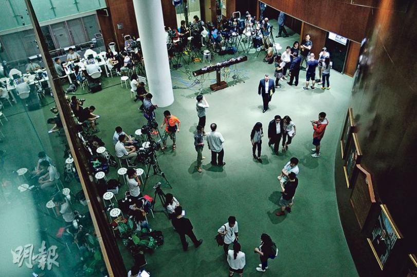 政改表決這大事件吸引大批傳媒到立法會採訪，會議廳門外嘅大堂人來人往，不時有電視台記者搵議員做現場訪問報道，立法會秘書處也夠體貼，擺出3個「咪兜」畀記者放咪。（郭慶輝攝）