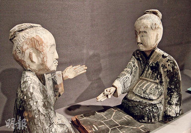 漢代民間生活相關展品﹕甘肅省博物館藏。兩個木俑正在玩六博，手持棋子籌碼在棋盤下棋。六博是漢代非常流行的博弈，玩法已失傳，據說像猜枚，另有一粒共18面的銅骰子，屬當年飲酒娛樂時的賭博器具，印有1至16的數字，餘下兩面為「酒來」和「驕」，擲中將被罰喝酒等。（李澤彤攝） 漢代民間生活相關展品﹕五子漆奩（左及中）、銅鏡（右下）、眉筆與眉石（右上）同為漢代婦女化妝用具。漆奩（音「廉」）用作放化妝品，流行於戰國至唐宋，婦女會用眉筆塗上石墨畫眉，及以米製成粉末作粉底、以油脂和丹砂製口紅。（李澤彤攝） 漢代民間