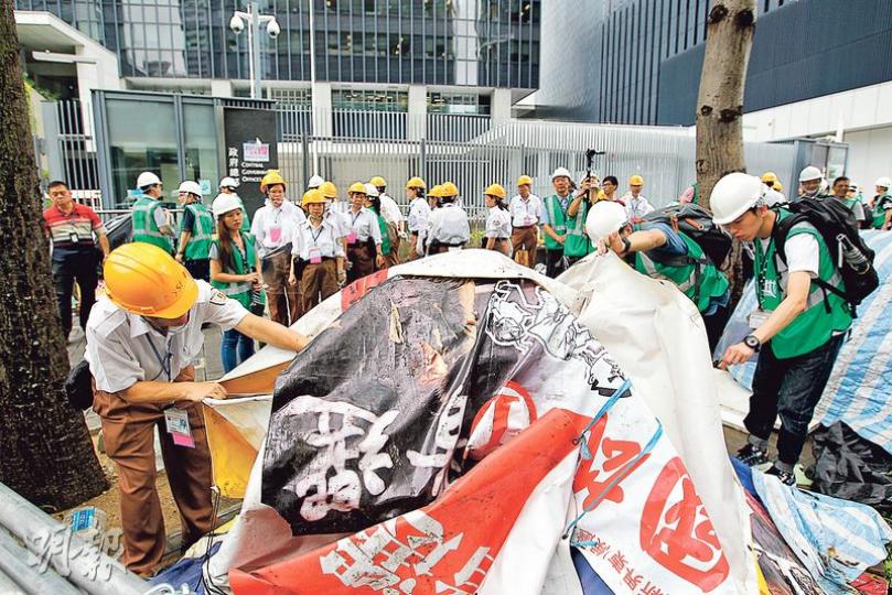 政府部門昨派出以地政總署人員為主的人員，到添美道清理帳篷，並先在要拆走的帳篷上以紅漆噴上X字，再逐一拆走。（郭慶輝攝） 自去年9月佔領運動以來，金鐘添美道行人道一直置有示威者的帳篷及雜物，左圖為政府派員清理帳篷前的日前情况，右圖為昨午清理完畢後的街道及路面。（資料圖片、郭慶輝攝）