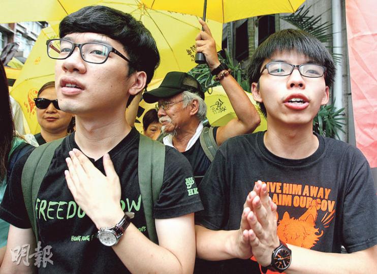 學聯秘書長羅冠聰（左）和學民思潮召集人黃之鋒（右）昨在律師陪同下到西區警署接受預約拘捕。（李紹昌攝）