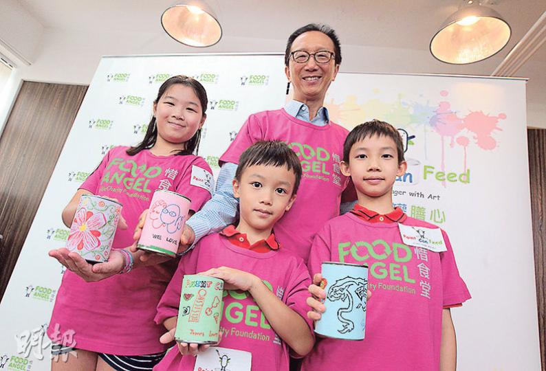 前財政司長梁錦松（中）帶同大女Amy（左）、二仔Edward（右）和細仔James（前）出席活動，齊齊畫罐頭，希望鼓勵年輕人透過參與罐頭設計比賽活動發揮創意。（李澤彤攝）