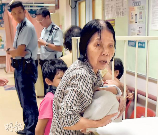 蘇婆婆拖着7歲孫女，抱着另一初生男孫，陪同昏迷男嬰送院。獲悉愛孫不治後，她仍要忍痛繼續照顧兩孫兒。（林智傑攝）猝死男嬰的父母事後趕赴醫院了解，其父（左）聲言3名兒童留在家時，均有成年人看管。（林智傑攝）蘇婆婆獲悉痛失愛孫後，一度情緒激動要由醫護人員安慰，但她迅速收拾心情，強忍淚水，努力照顧另一名初生男嬰及7歲孫女。（林智傑攝）天水圍天耀邨耀民樓揭發雙屍案，其中身為女婿的男死者疑失救致死，八旬外父疑因欠缺照顧餓斃。兩遺體昨午由仵工移送殮房檢驗，以確定死因。（賴俊傑攝）