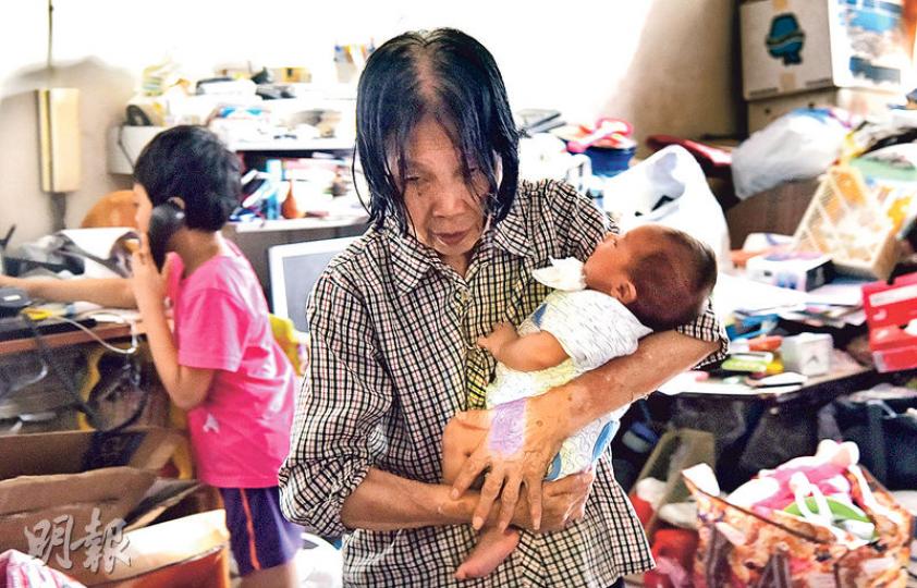 失去孫兒還未走出陰霾的蘇婆婆，昨日一臉愁容，繼續照顧兩名孫兒，但仍為其子講好說話。（賴俊傑攝）猝死男嬰的父親（右）及疑為生母女子昨晨到葵涌殮房認屍。（賴俊傑攝）
