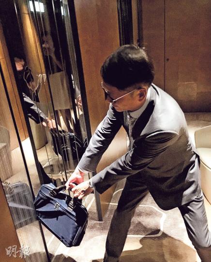 許晉亨出力扯着被夾的公事包（圖），李嘉欣唔幫手，還捕捉老公狼狽的一刻，這個老婆真調皮。（微博圖片）（攝影﹕娛樂組）