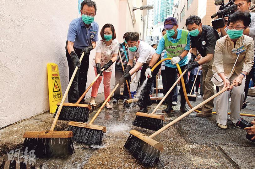 食衛局長高永文（左四）昨到灣仔鵝頸街市外，與一眾區議員及食環署職員洗街，把污水推到坑渠內。眾人擦地約10分鐘。（林俊源攝）官員上午到場大清洗後，約下午6時半，灣仔鵝頸街市陳東里未見有垃圾，但有人把白色發泡膠箱等暫放街頭（圖左），有人說這些物品會有人前來領走，拿去分類回收。（林俊源攝）