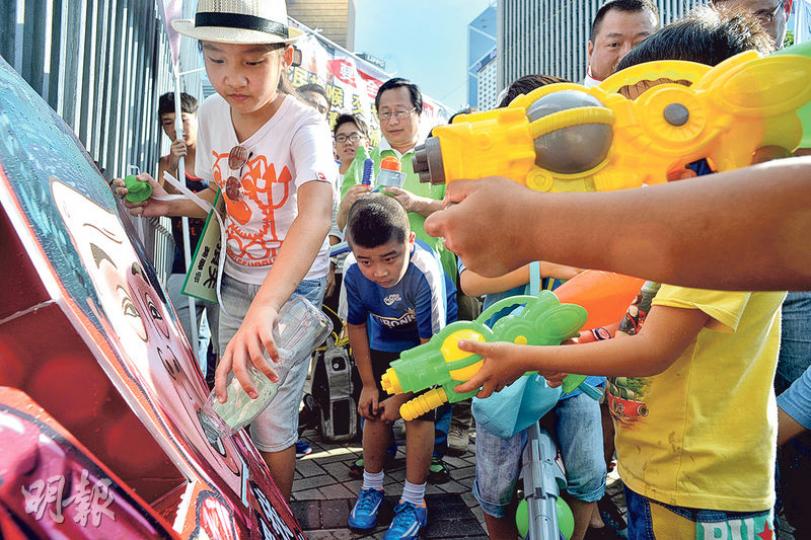 由受鉛水影響屋邨居民組成的「食水苦主大聯盟」，昨遊行至特首辦門外，小童（圖）用裝有家中食水的水槍向特首紙牌射水及倒水，並將鉛超標食水掛在大閘上，表達不滿。（蘇智鑫攝）