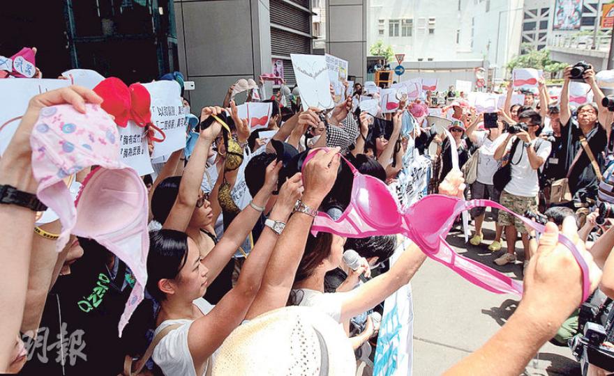 多個婦女團體等共逾百人昨日在灣仔警察總部外舉起胸圍及標語，高叫「胸部不是武器」口號，抗議早前有女示威者被指「胸部襲警」罪成。（李澤彤攝）職工盟郭紹傑昨參與請願，並戴上黑色胸圍，發言時說今次事件中女性受辱，但男性日後也可能受影響，「分分鐘警方就會話我哋（男性）用陽具攻擊警察」。（李澤彤攝）