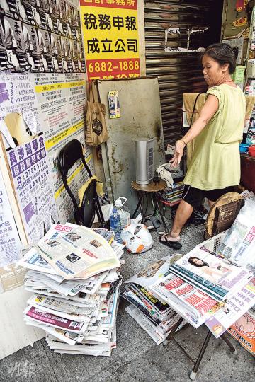 報檔大疊報紙被人用豆漿水淋濕，女報販事後把報紙擺放路邊，已無法出售需要報銷。（蔡方山攝）