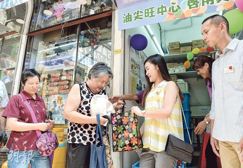 民社服務中心「糧友行動」喺油麻地開設油尖旺中心，望有更多店東捐出食物幫助有需要嘅人。中心開幕即向街坊派麵包。（鍾林枝攝）