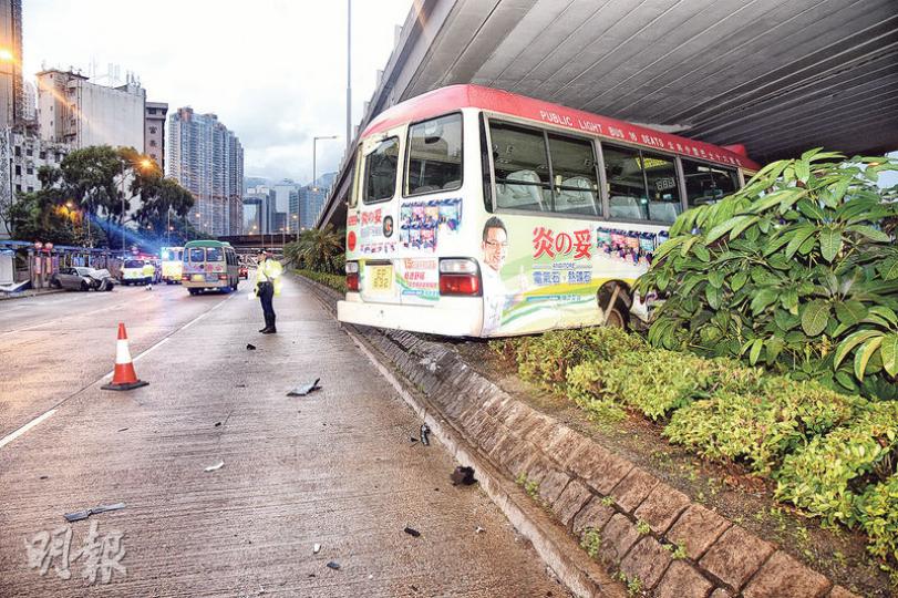 車禍中，公共小巴被撞至越過約兩呎高石壆，衝上橋底花槽，一名男乘客受傷需送院治理。（蔡方山攝）肇事私家車與公共小巴相撞後，再失控剷上路邊巴士站撞毁廣告燈箱，幸當時巴士站未有候車乘客，否則後果不堪設想。（蔡方山攝）