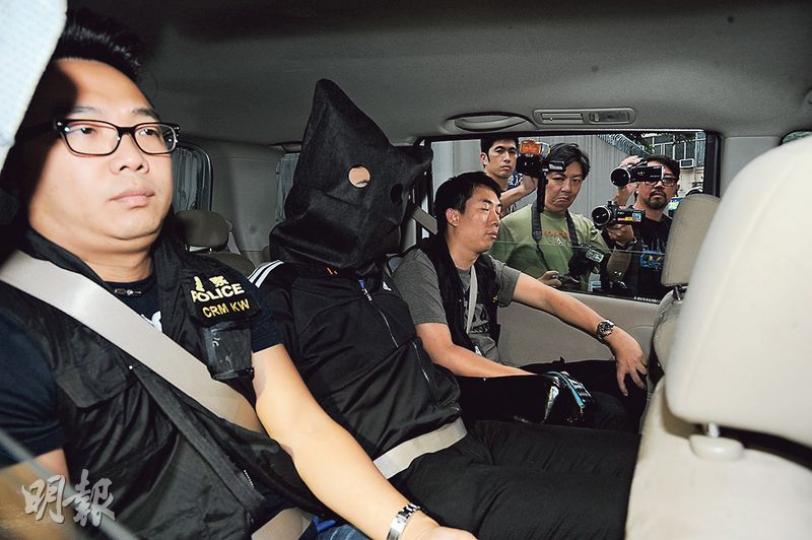 涉嫌透過手機程式利誘少女賣淫的「網上馬伕」，遇女警放蛇拘捕後，昨被黑布蒙頭押返警署扣查。（樊銳昌攝）