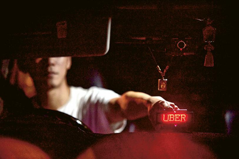 不欲上鏡的李先生與其他司機自行訂製了Uber燈牌，上下班繁忙時間途經巴士及的士站便展示燈牌，令乘客知道附近有Uber車可供預約。（鄧宗弘攝）