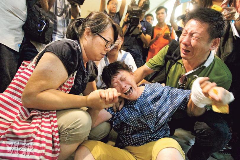在爆炸中喪生的內地男遊客翁達（下圖），其家人到達殯儀中心辦理認屍手續期間，翁母（中）一度痛哭跌坐地上，不停搥胸，同行親友邊流淚邊扶着她安慰。（林俊源攝）