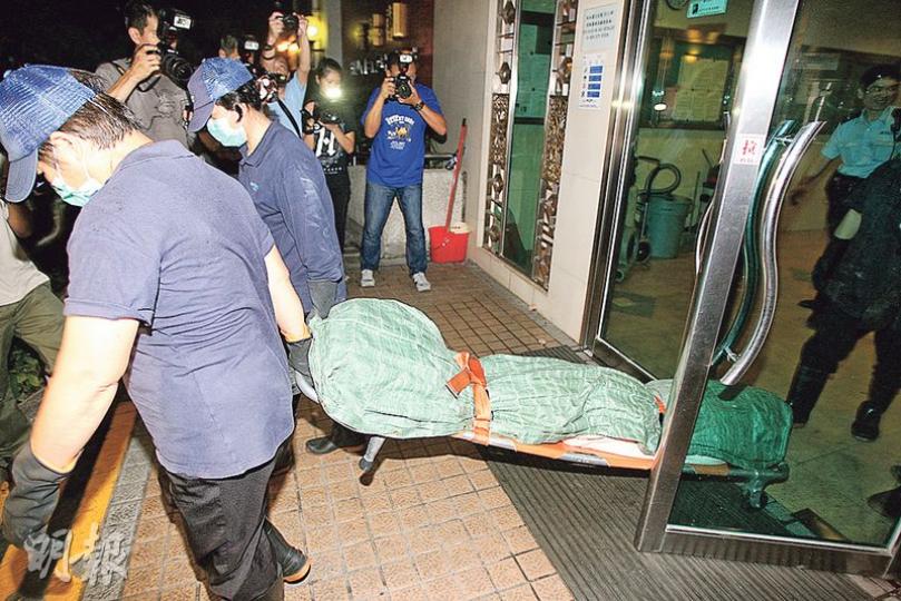 起火單位戶主的兒子被發現倒斃天台機房旁，屍體由仵工舁送殮房。（伍浦鋒攝）